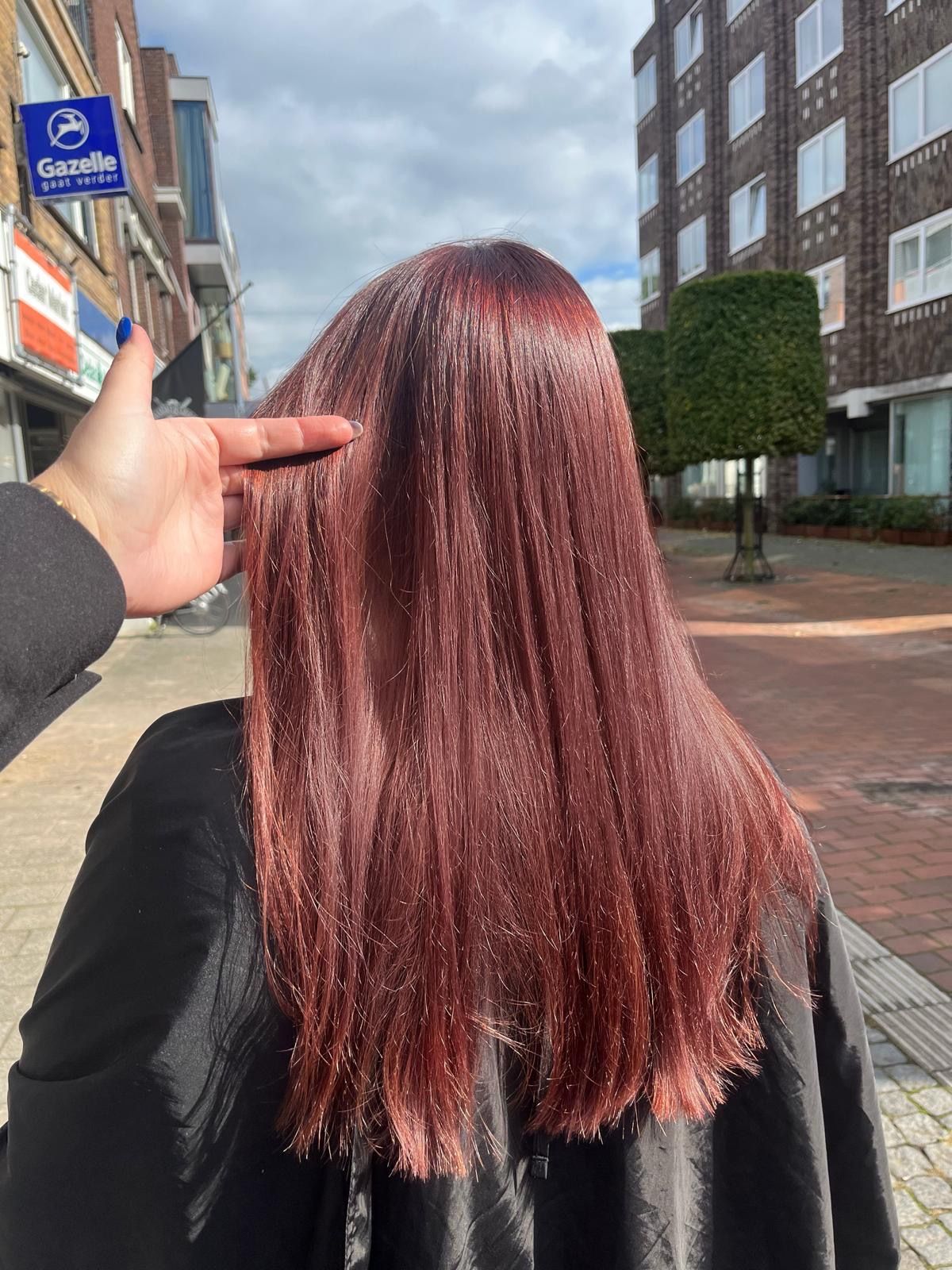 Lang glanzend rood haar, steil geföhnd